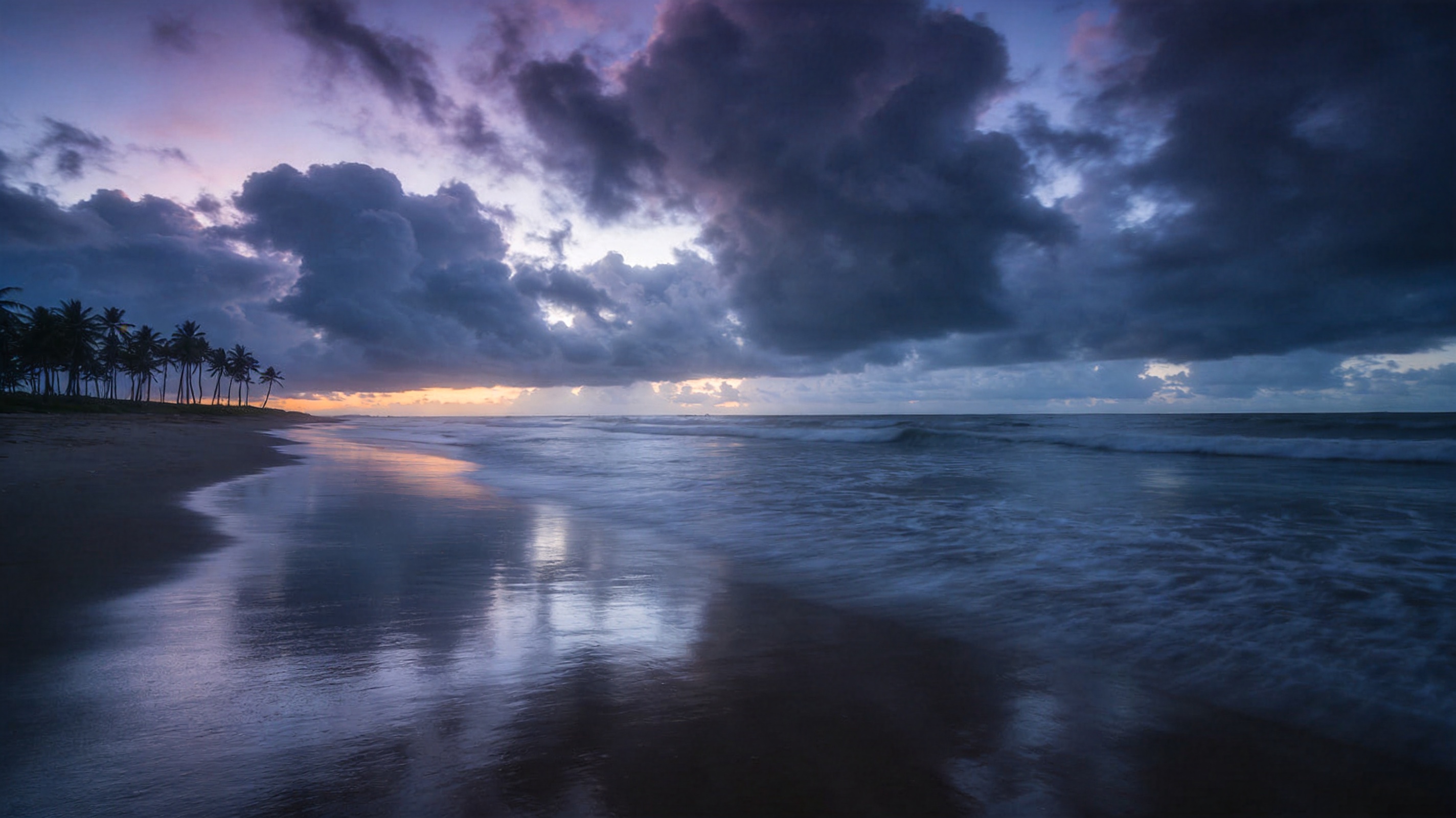 Empty tropical beach at dawn under monsoon clouds with wet reflective sand and distant coconut palms.